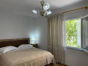 a bedroom with a bed and a window at Lovely one-bedroom apartment with private entrance in Tirana