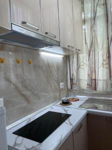 a kitchen with white marble counter top and a stove at Lovely one-bedroom apartment with private entrance in Tirana