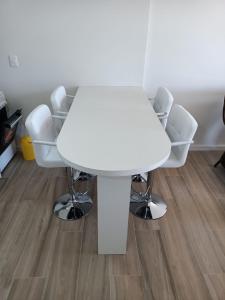 una mesa blanca y sillas en una habitación en Unica, en Piriápolis