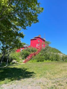 uma casa vermelha sentada no topo de uma colina em Captain's Residence em Marquette