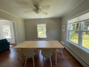 uma mesa de jantar com cadeiras e uma ventoinha de tecto em Captain's Residence em Marquette
