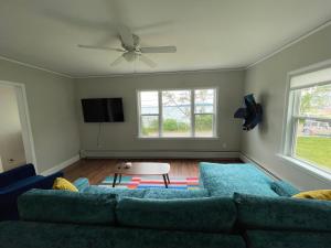 uma sala de estar com um sofá azul e duas janelas em Captain's Residence em Marquette