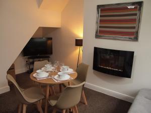 a dining room with a table and chairs and a television at Hello Middlesbrough in Middlesbrough