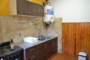 cocina pequeña con fregadero y fogones en El Nogal en Sierra de la Ventana