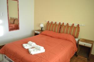 1 dormitorio con 2 toallas en una cama naranja en El Nogal en Sierra de la Ventana