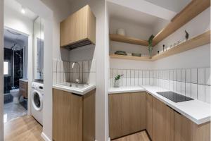 a kitchen with a sink and a washing machine at Little Attic by CityLife Suites in Bucharest