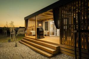 een huis met een houten veranda met een terras bij Luxury home Alpha, pool, camp Volme - nearby Kamenjak in Banjole