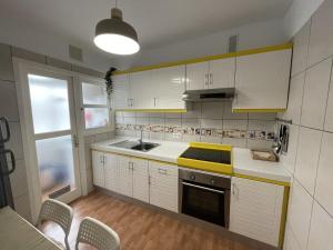 una cucina con armadi bianchi e lavandino di Beautiful 3 Bd. Apartment in La Laguna City Centre a La Laguna