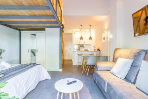 Cette chambre comprend un lit, un canapé et une table. dans l'établissement OleHolidays 405 Loft Romana Playa junto al mar, à Marbella