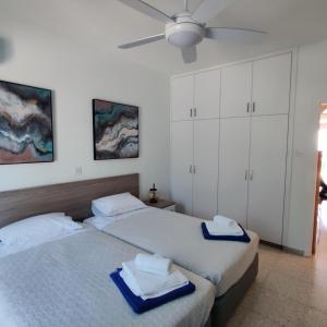 two beds in a bedroom with a ceiling fan at Lovely 1-bedroom unit @ fabulous location in Paphos City