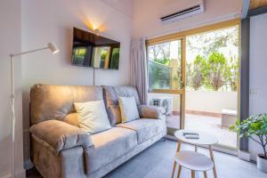 ein Wohnzimmer mit einem Sofa und einem Tisch in der Unterkunft OleHolidays 405 Loft Romana Playa junto al mar in Marbella