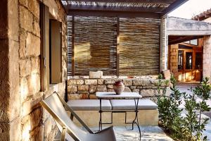 une table et des chaises assises sur une terrasse dans l'établissement Nikolaou residence, à Égine