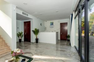 a lobby with a white wall and two doors at Graphica Black Sea in Shekvetili