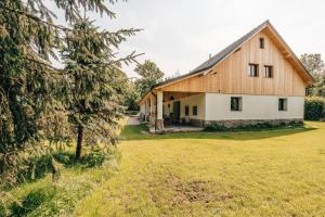 a barn with a large grass field next to it at Farma Mračov in Kadov