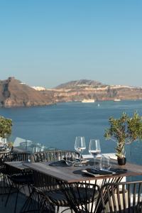 a boat sitting on top of a lake next to a body of water at La Perla Villas and Suites - Adults Only in Oia