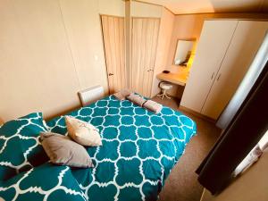 a bedroom with a blue bed with two pillows at The Hideaway in Cayton