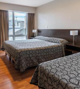 Habitación de hotel con 2 camas y balcón en Lagos Andinos en San Carlos de Bariloche