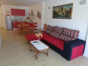 a living room with a red couch and a table at Chajofe 8 in Los Cristianos