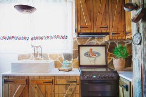 a kitchen with wooden cabinets and a sink and a stove at Traditional house Alexis Coco with pool and fire place in Tríkorfon