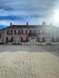 a large brick building with the sun behind it at La Résidence du Canal de Bourgogne in Montbard