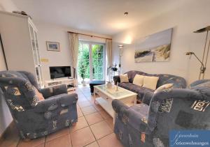 a living room with blue couches and a tv at Friesenhain Ferienwohnungen in Sankt Peter-Ording
