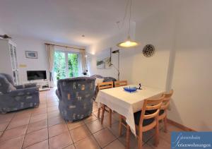a living room with a table and chairs at Friesenhain Ferienwohnungen in Sankt Peter-Ording +15 photos
