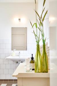 two green vases sitting on a counter in a bathroom at Hotel Saxkjøbing in Sakskøbing