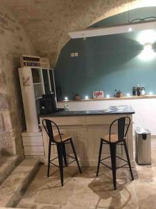 a kitchen with two chairs and a counter with a refrigerator at DOMAINE MARY'S in Barjac