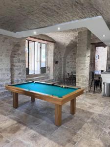 een pooltafel in een kamer met een stenen muur bij DOMAINE MARY'S in Barjac