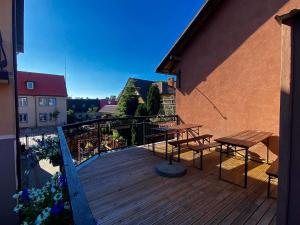 a balcony with tables and benches on a building at Pokoje goscinne Marcin in Łeba