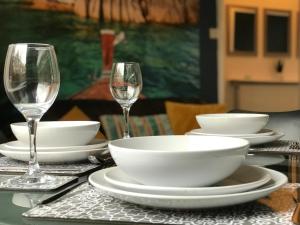 una mesa con platos, tazones y copas de vino en Bright Spacious 3-bed with office & patio, Preston en Preston