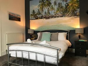 1 dormitorio con 1 cama y una pintura de playa en Bright Spacious 3-bed with office & patio, Preston en Preston