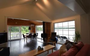 uma sala de estar com um sofá e uma mesa em Cozy holiday home with its own jetty and panoramic views of Norra Orsjon em Arvika
