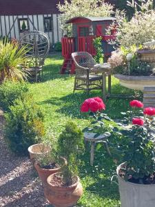 een tuin met stoelen en potplanten en bloemen bij La Cour Du Puits Chambre Victor in Cormeilles
