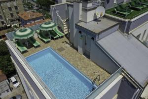 a large swimming pool with a large building behind it at Amadei Hotel Figaro & Apartments in Pesaro
