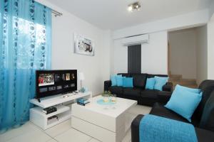 een woonkamer met een bank en een televisie bij Villa Nissinia - Nissi Beach Area in Ayia Napa