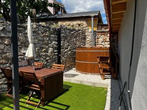 patio con tavolo, sedie e ombrellone di Loft Pihenő és Wellness Ház a Balatonfüred