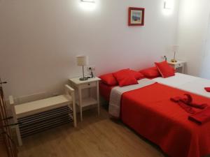 a bedroom with two beds with red pillows at Chajofe 8 in Los Cristianos