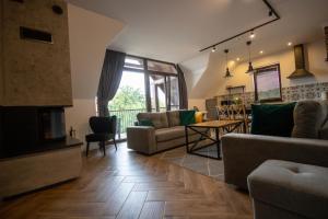 a living room with a couch and a fireplace at Apartamenty Pod Kominkiem in Rydzewo