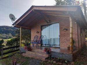 a tiny house with a deck and a patio at Sossego do Interior III in Nova Petrópolis
