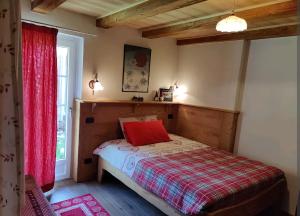 Un dormitorio con una cama con una almohada roja. en Fuchs Haus en Formazza