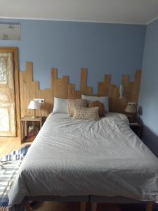 una camera con un grande letto con testiera in legno di La grange aux dîmes a Walcourt