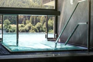 einen Pool mit Blick auf einen Wasserkörper in der Unterkunft Hotel Kohlmais in Saalbach-Hinterglemm