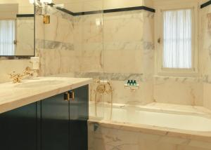 a bathroom with a tub and a sink at Hotel la Ponche in Saint-Tropez