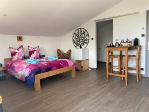 a bedroom with a large bed and a table at Le clos des Pommiers in Uffholtz