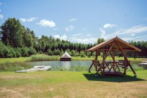 - un kiosque en bois installé à côté d'un lac dans l'établissement Marguse Metsamajad, à Pärnu