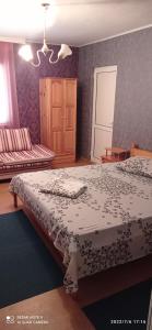 a bedroom with a bed with a black and white blanket at Guest House Sunrise in Shabla