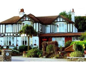 a house with a palm tree in front of it at Newton House in Torquay