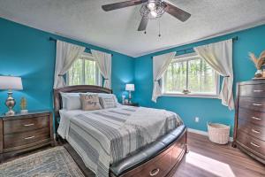 een slaapkamer met blauwe muren en een bed met een plafondventilator bij Pet-Friendly Home with Hot Tub in Northern Michigan! in Johannesburg