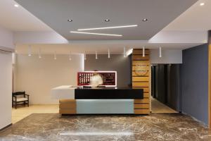 a lobby with a counter and a clock on the wall at Aphrodite Beachfront Hotel by Konnect, Roda in Roda